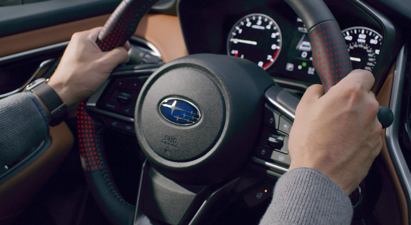 Deux mains sur le volant d'un véhicule Subaru sortant de travaux de carrosserie chez le Groupe Leclair